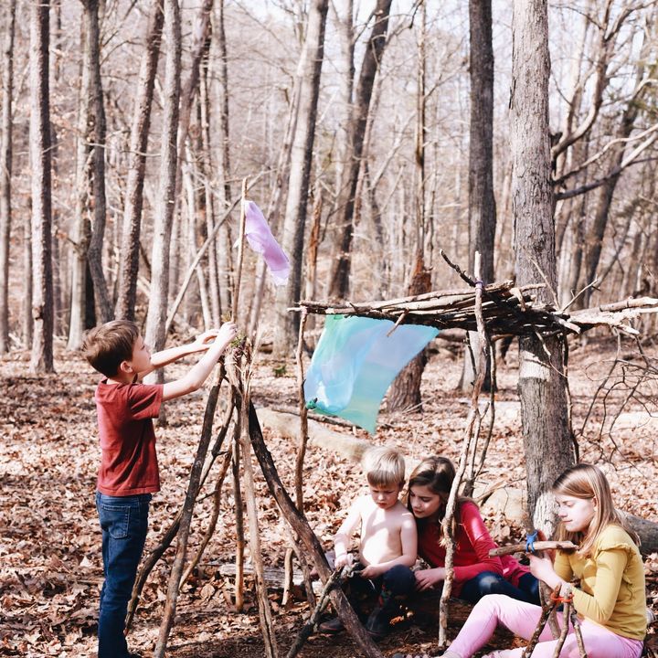 Kids building a stick fort in the woods